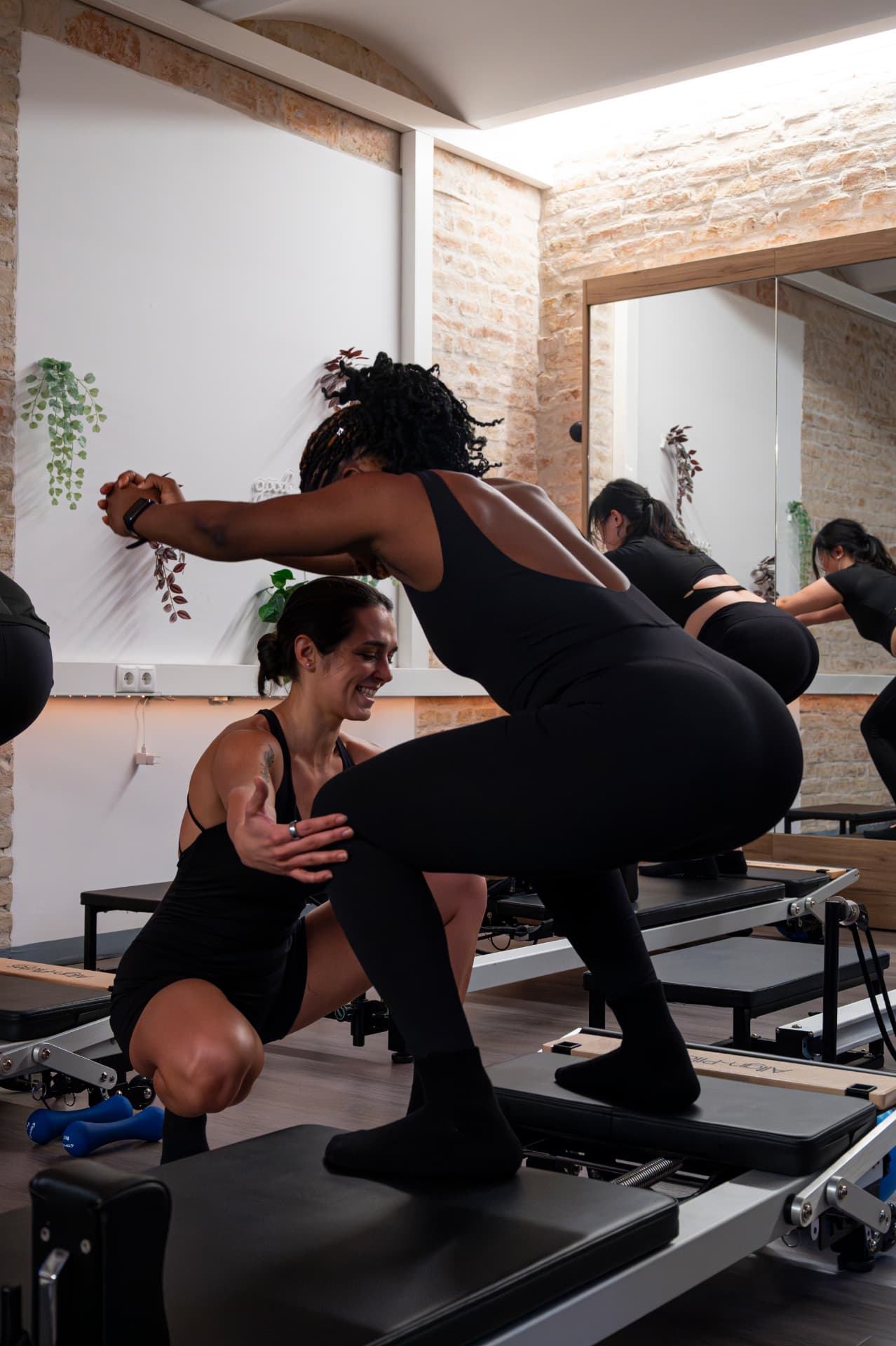 Jessie teaching a client on the reformer with attentive, hands-on guidance
